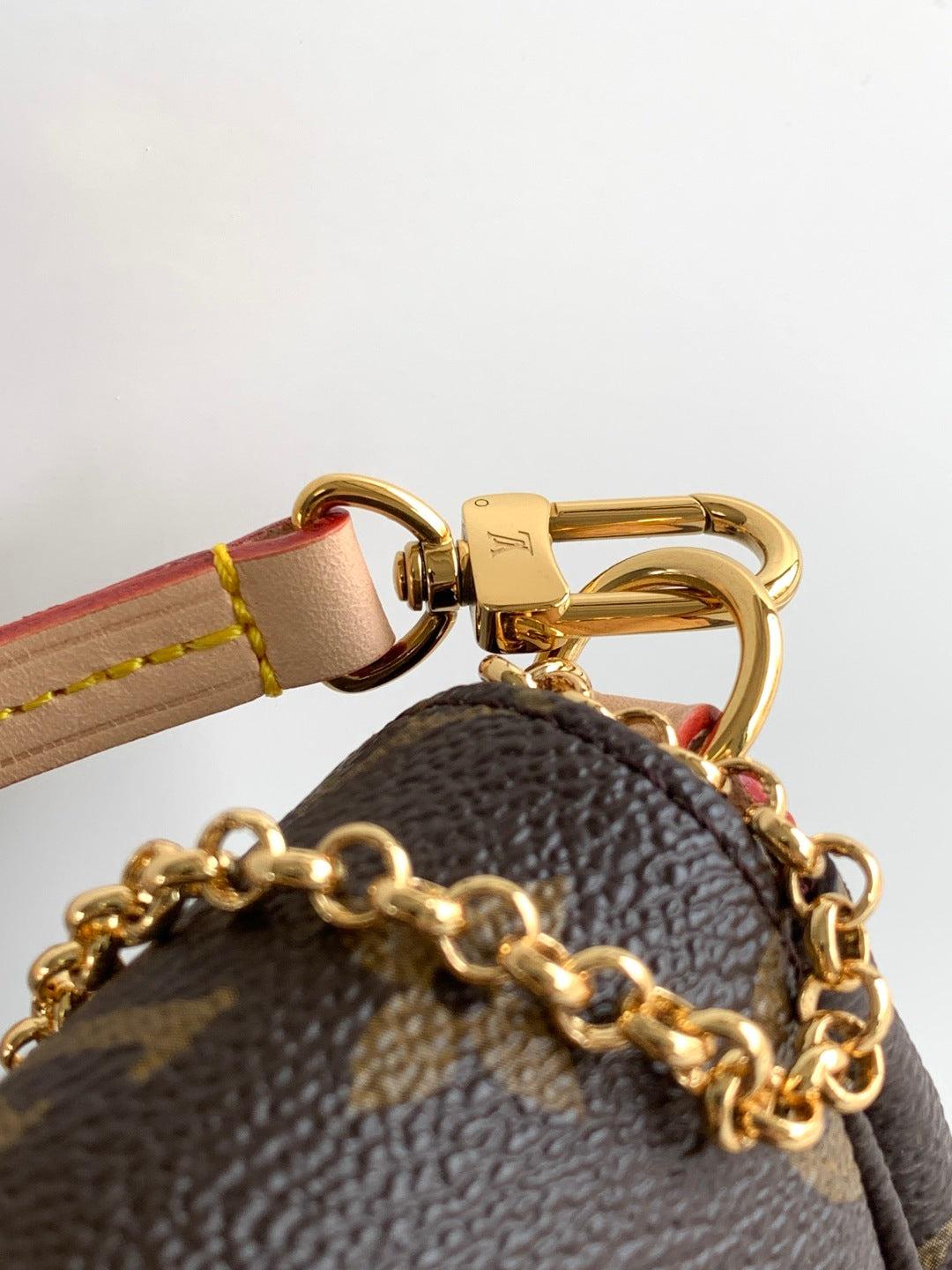 Louis Vuitton bag strap clasp and gold keyring with chain, brown leather and canvas trim.