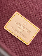 Louis Vuitton brand label tag on maroon fabric, stitched edges, Made in Paris, France.