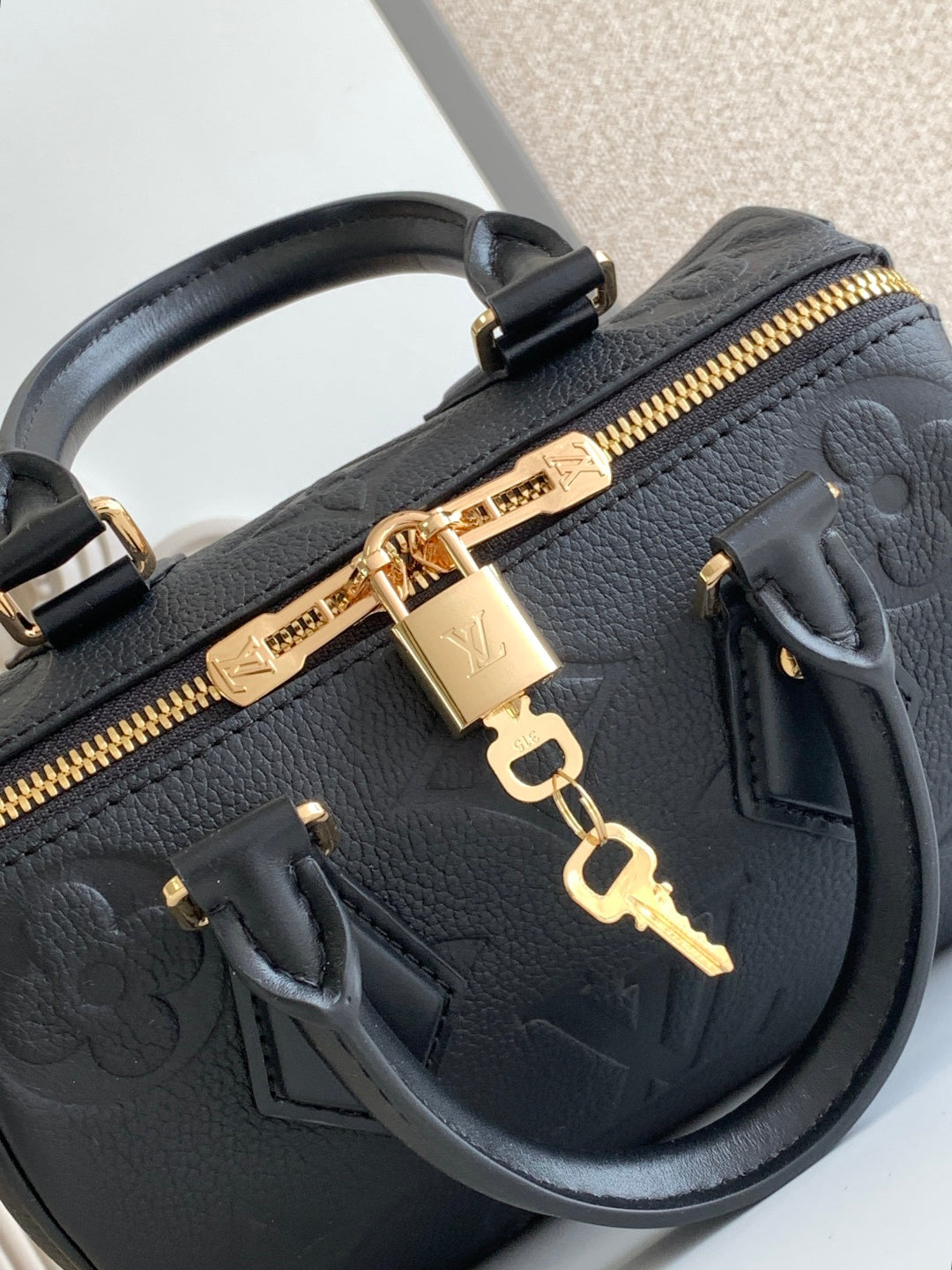 Louis Vuitton black leather handbag zipper detail with gold hardware