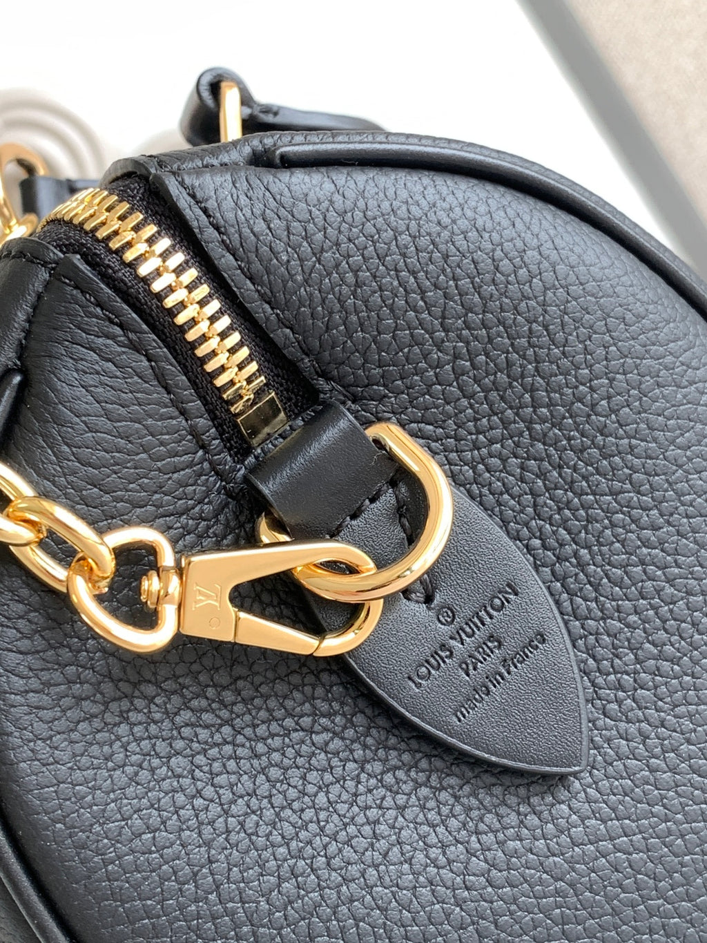 Louis Vuitton black leather handbag clasp and gold zipper pull