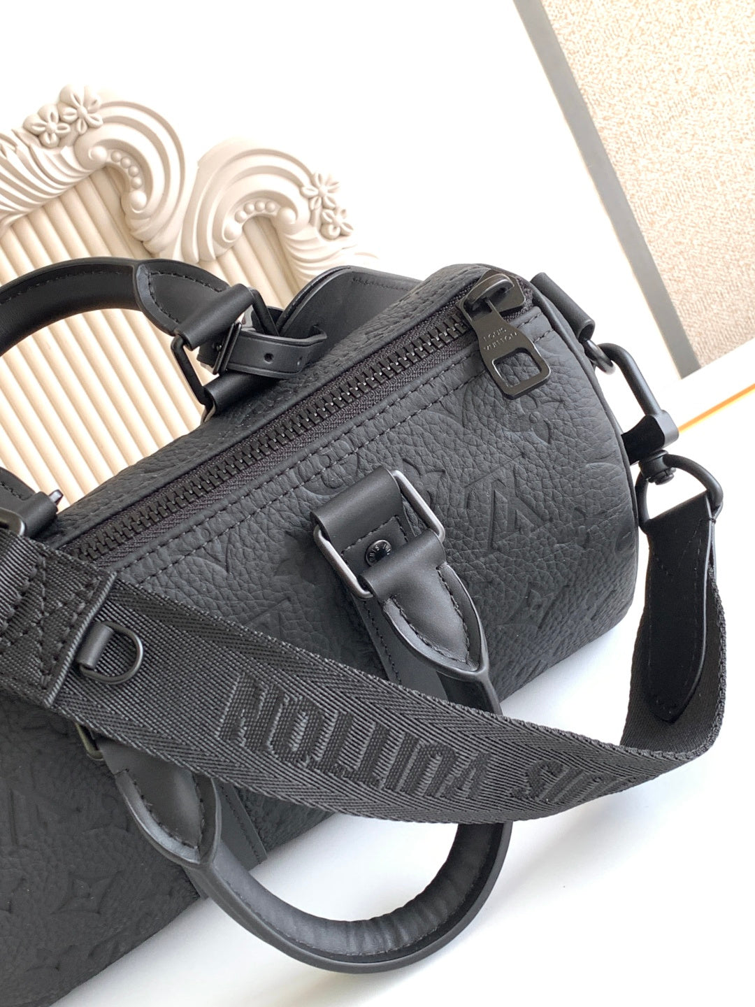 Louis Vuitton monogram crossbody bag, black textured leather with front zipper pocket.
