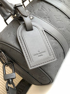 Louis Vuitton monogram bag close-up, light gray leather with zipper pull and strap.