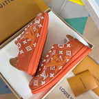 Orange monogram sneakers with white laces and tan tongue patch, top view pair