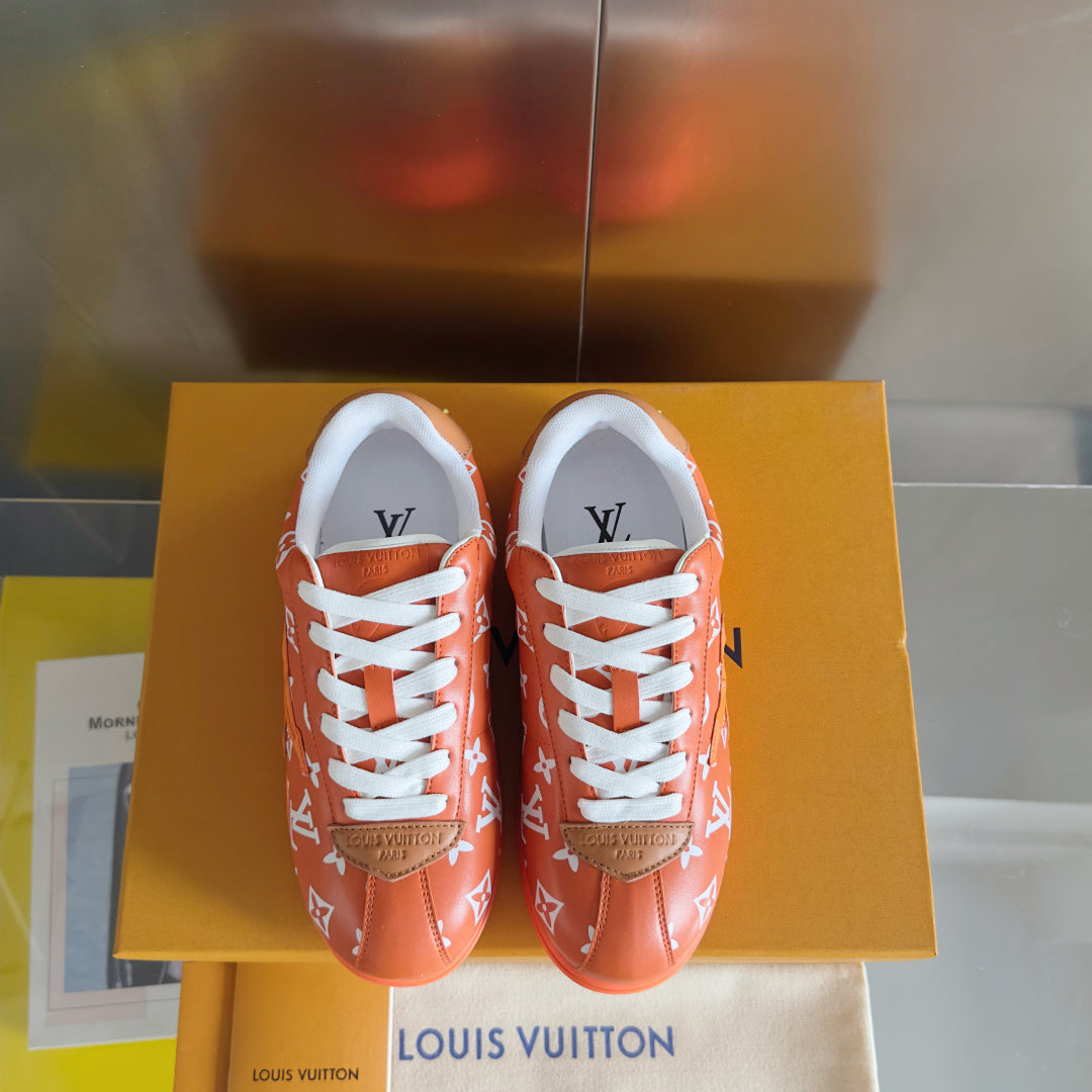 Orange monogram sneakers with white laces and white tongues, pair on box