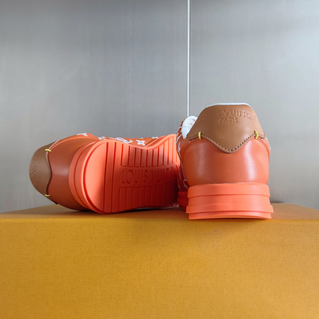 Orange sneakers with white laces, back view showing treaded orange sole