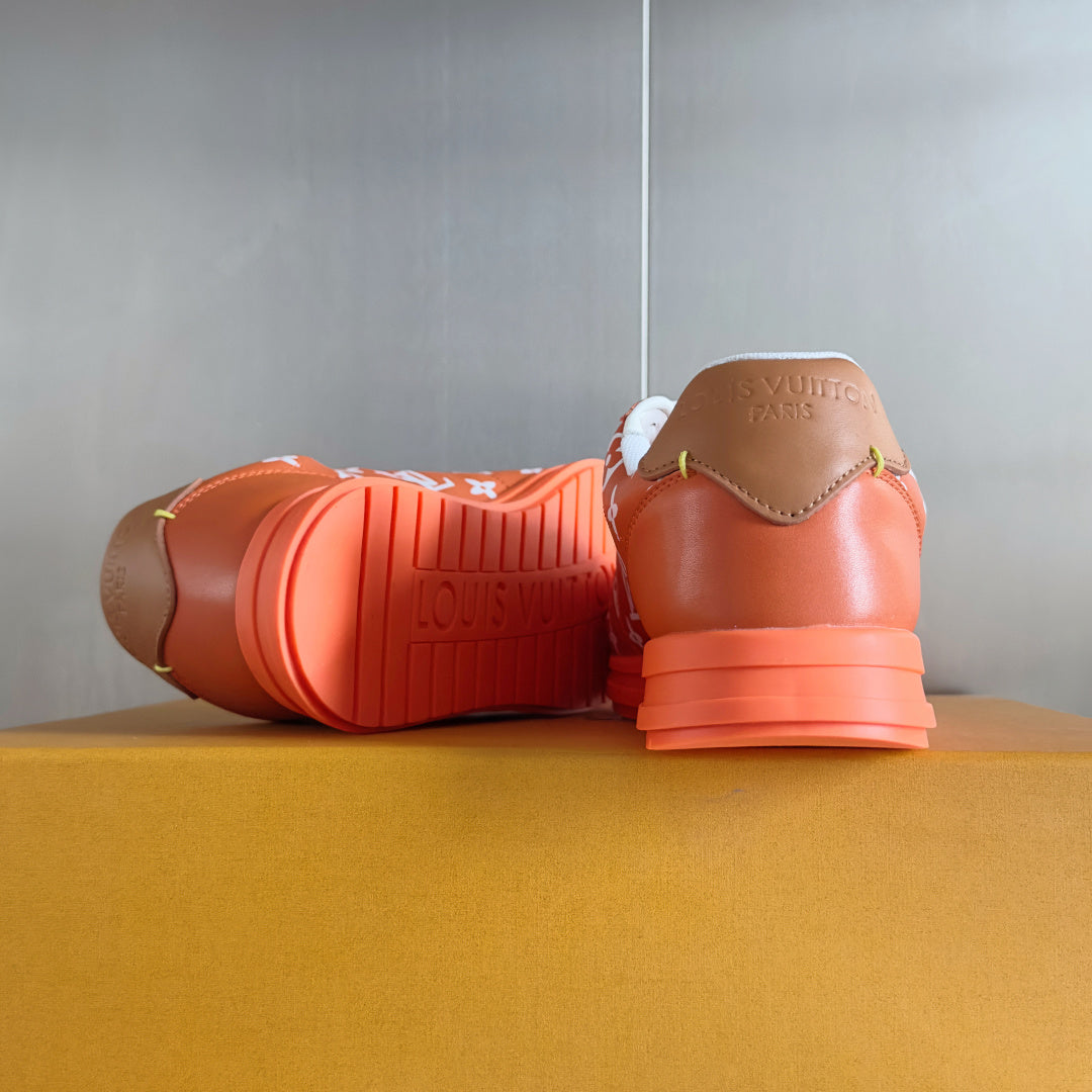 Orange sneakers with white laces, back view showing treaded orange sole
