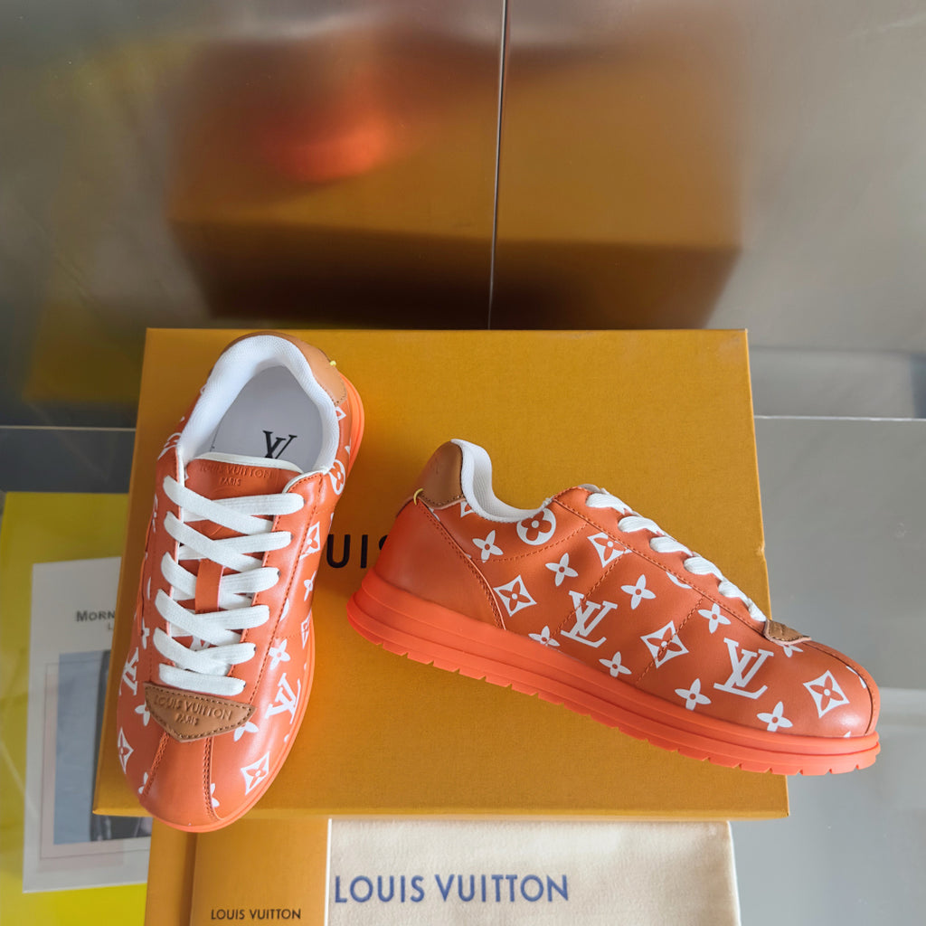 Orange Louis Vuitton sneakers with white laces and white monogram pattern, on box