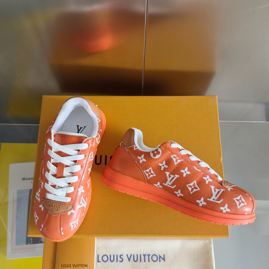 Orange Louis Vuitton sneakers with white laces and white monogram pattern, on box