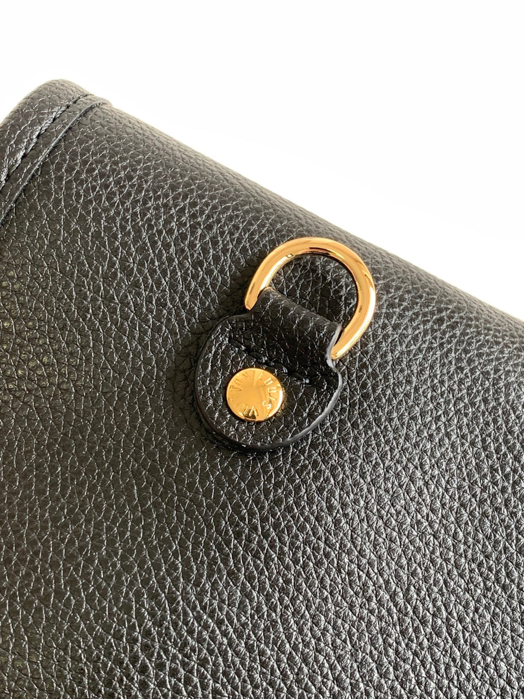 Louis Vuitton textured leather bag corner with gold-tone key ring pull