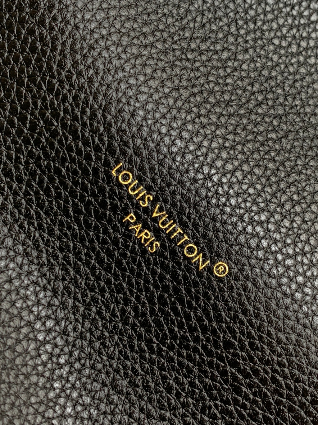 Louis Vuitton Paris logo on black textured leather with gold lettering
