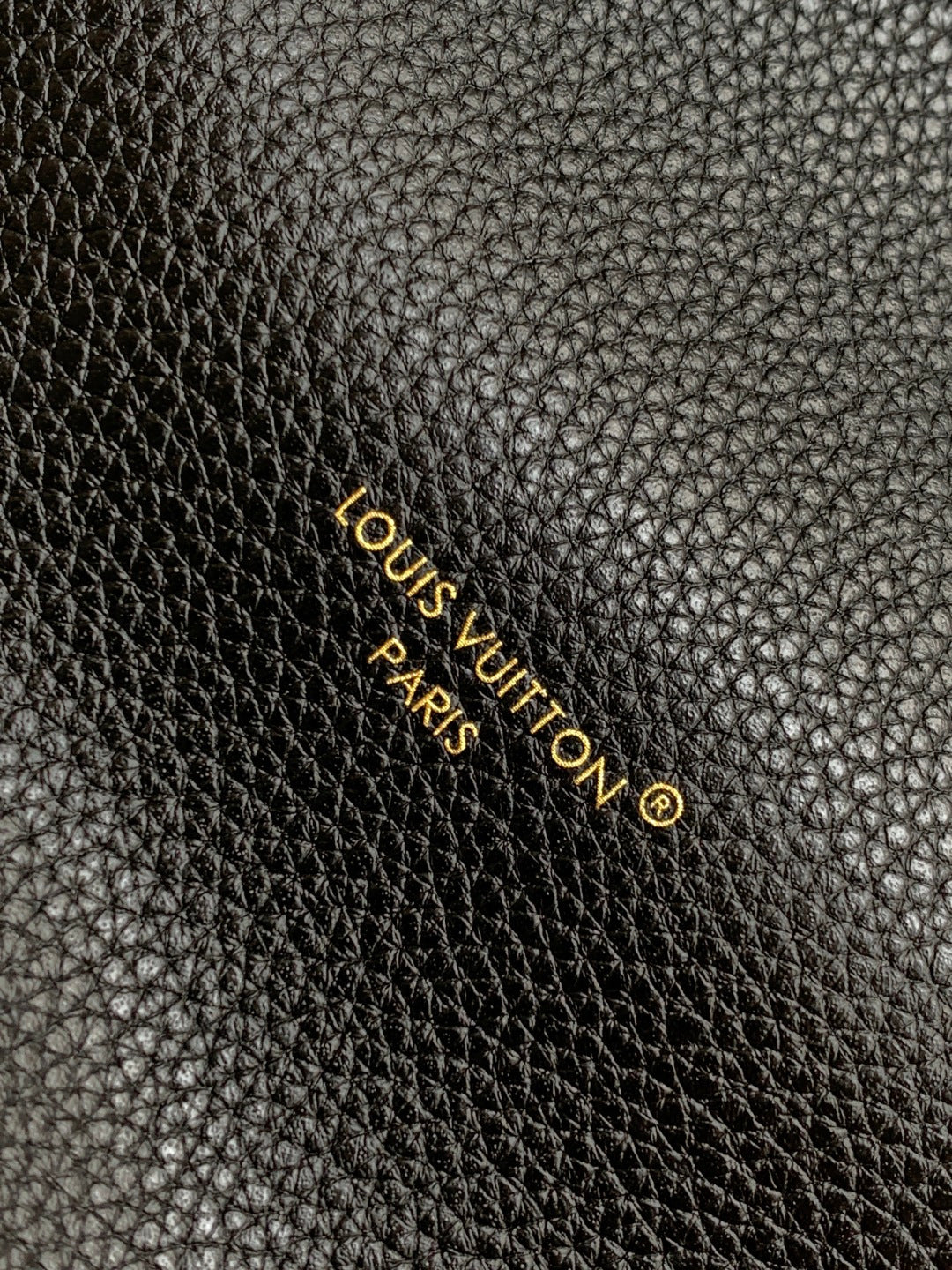 Louis Vuitton Paris logo on black textured leather with gold lettering
