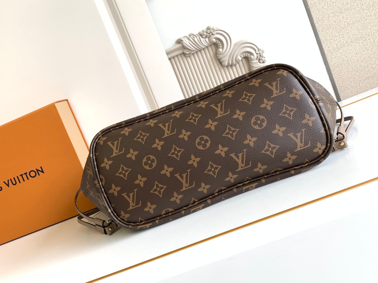 Brown monogram crossbody bag with rounded top and adjustable shoulder strap