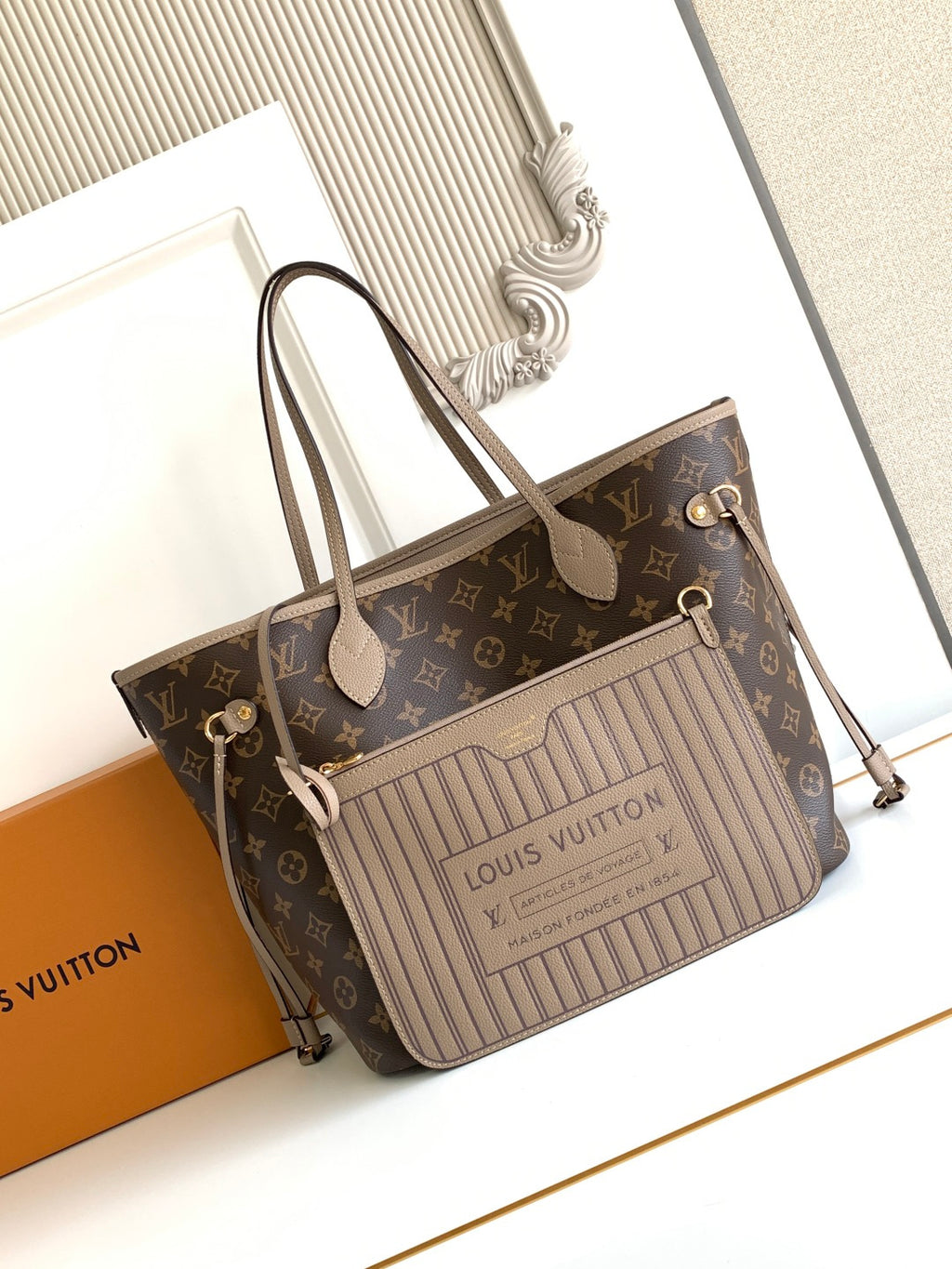 Brown monogram tote bag with light striped front panel, top handles, and zipper