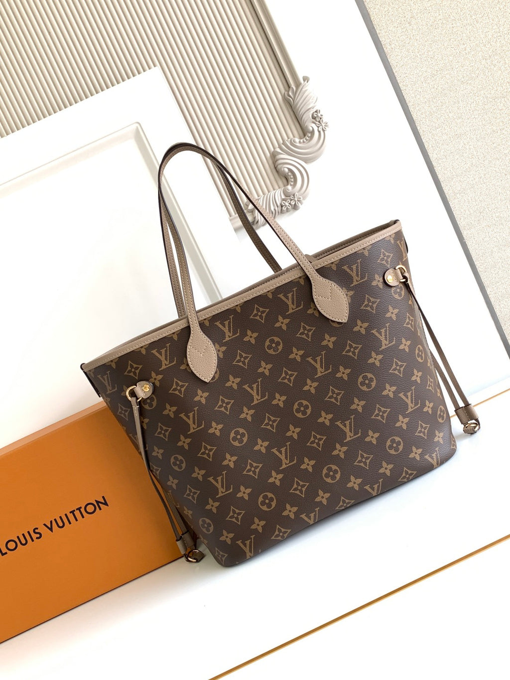 Brown monogram tote bag with front striped panel, top handles, and side strap details