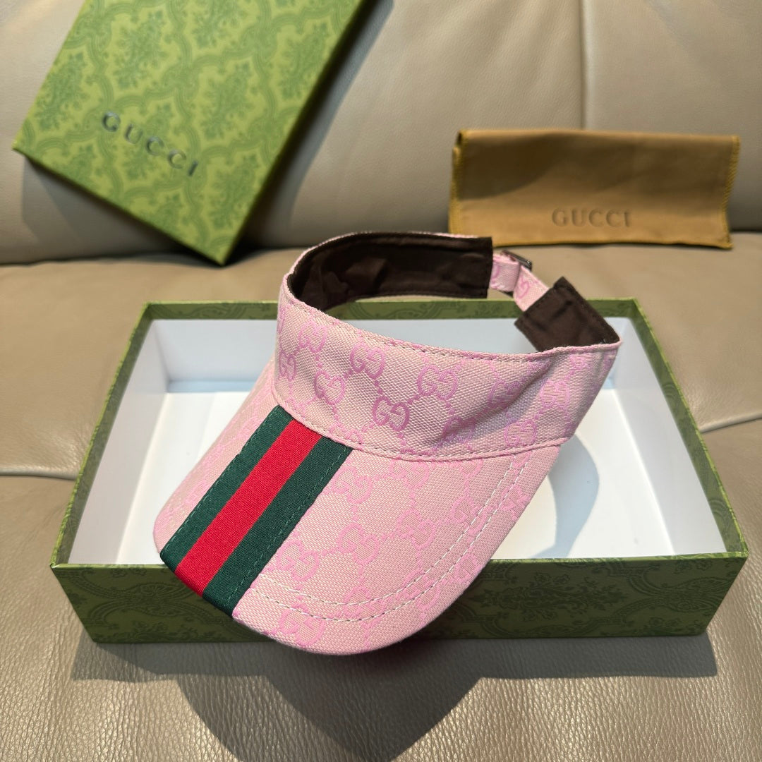 Pink Gucci visor cap with GG logo, green-red stripe trim, and dark interior