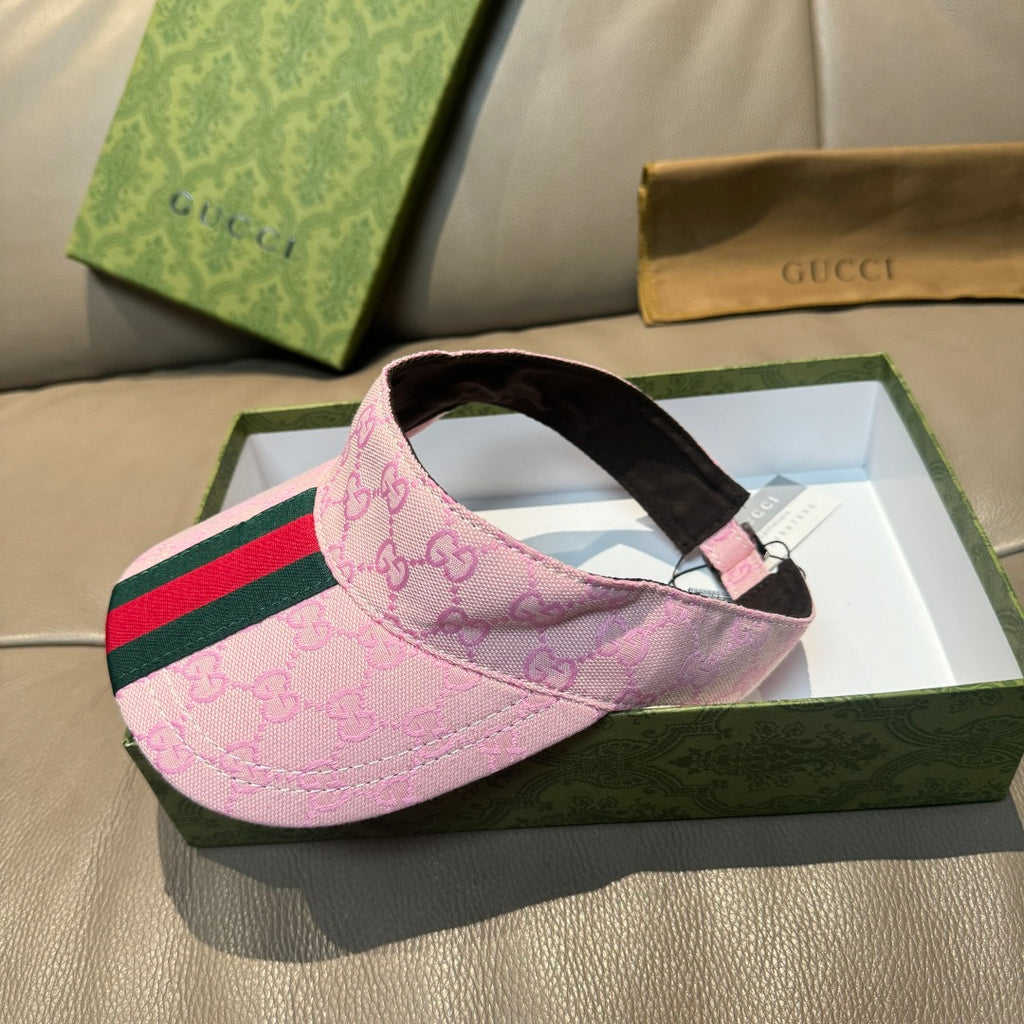 Pink Gucci visor cap with GG monogram, green-red stripe, and black underside