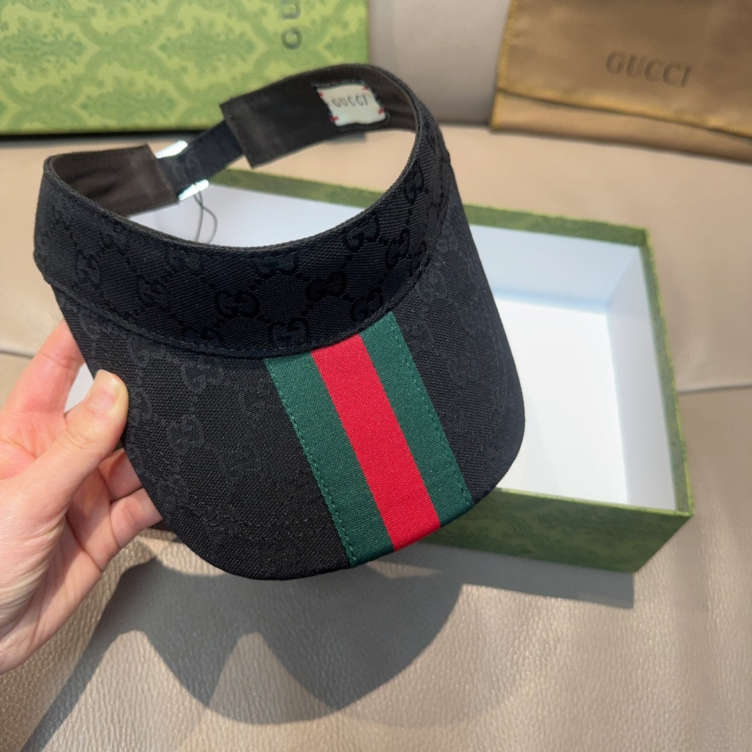 Gucci visor cap held up: dark GG jacquard with green and red stripe accent
