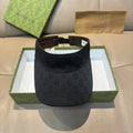 Gucci visor cap in dark monogram canvas, curved brim, adjustable strap.
