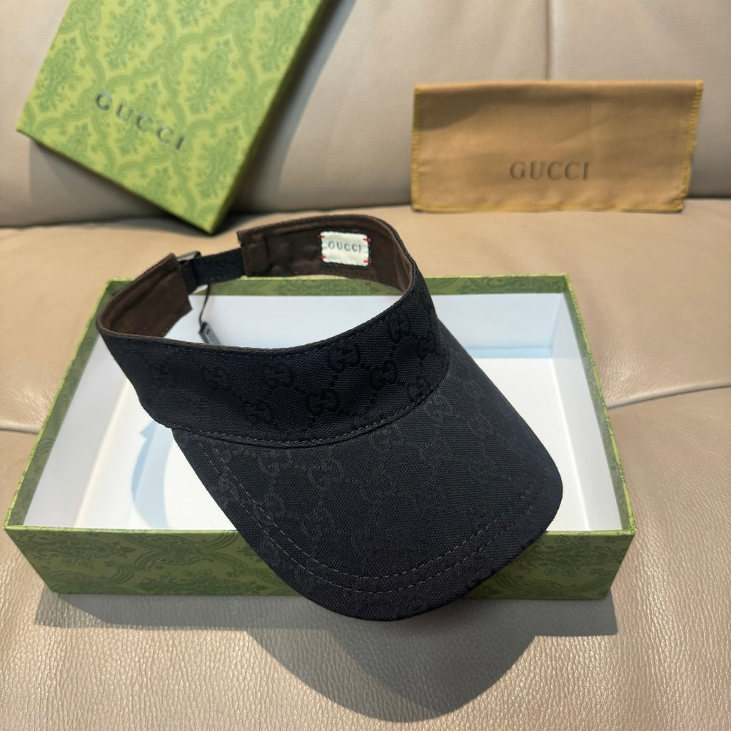 Gucci visor cap in dark monogram canvas, front profile with adjustable back strap.