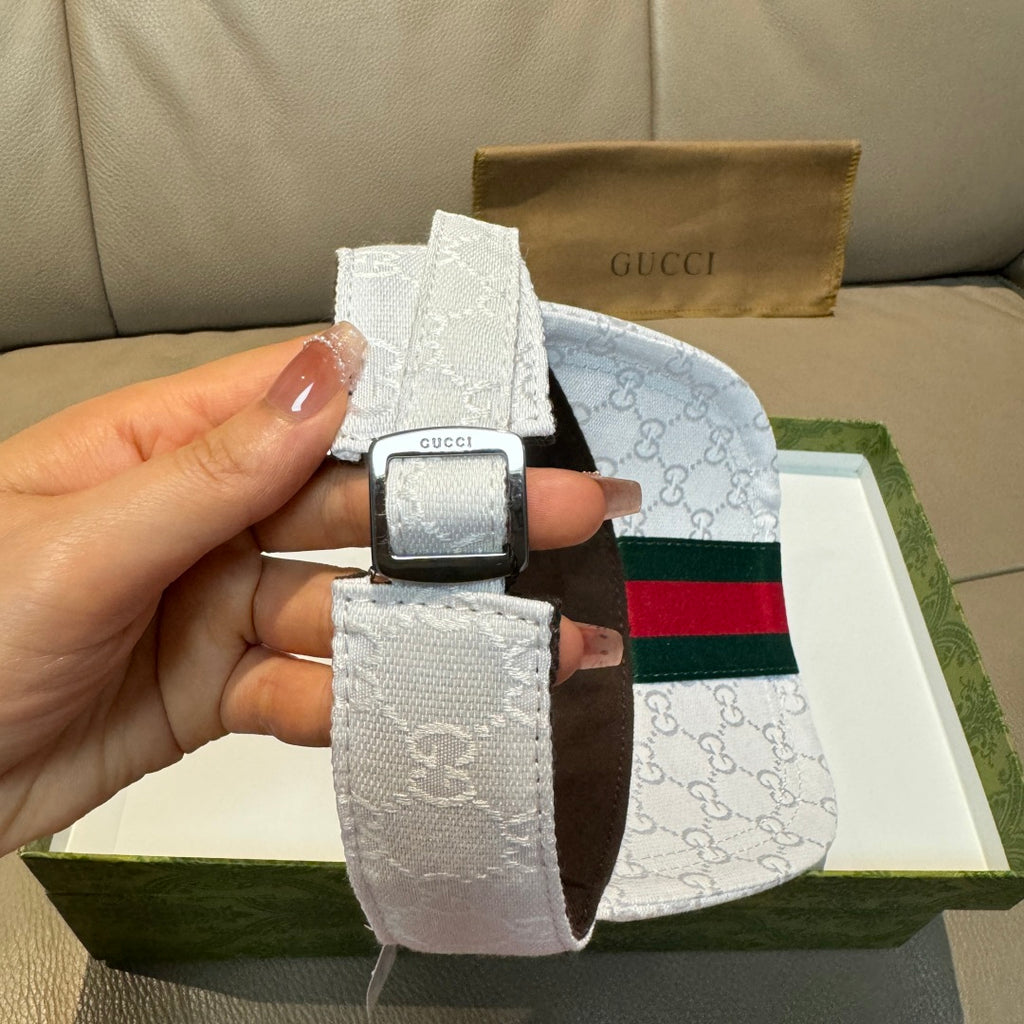 White GG-print visor cap strap detail with square buckle and green-red Web band