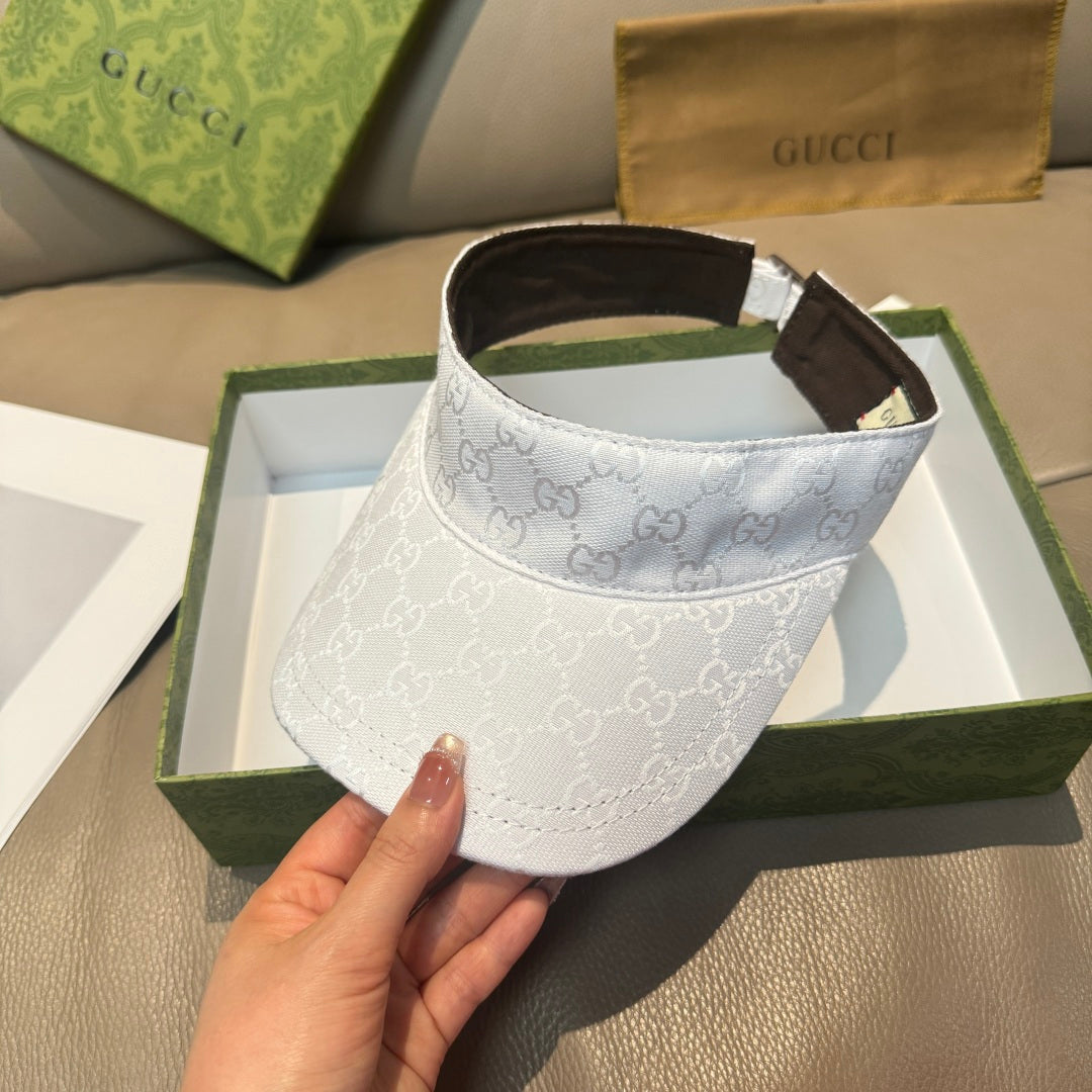 White GG-print visor cap angled view, brown inner band and adjustable strap