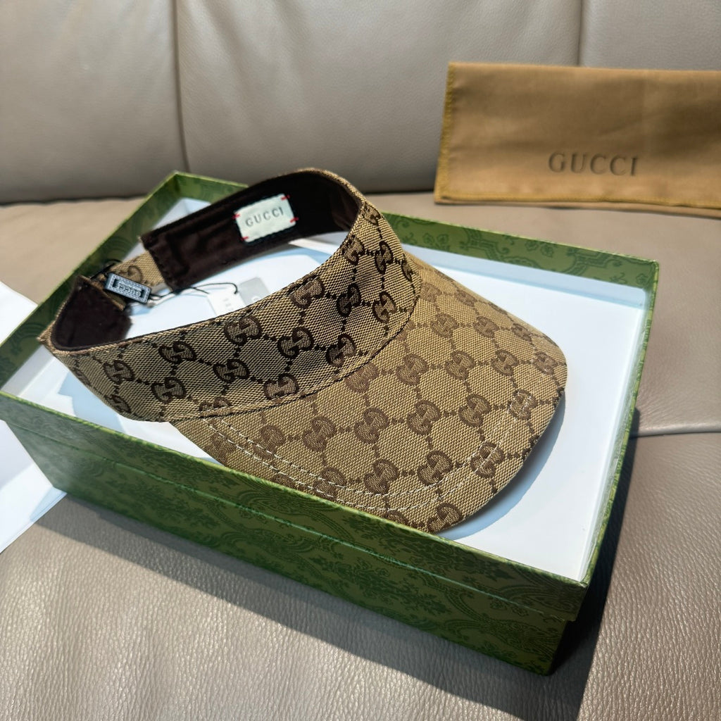 Brown GG monogram visor cap with black interior, front profile on green box