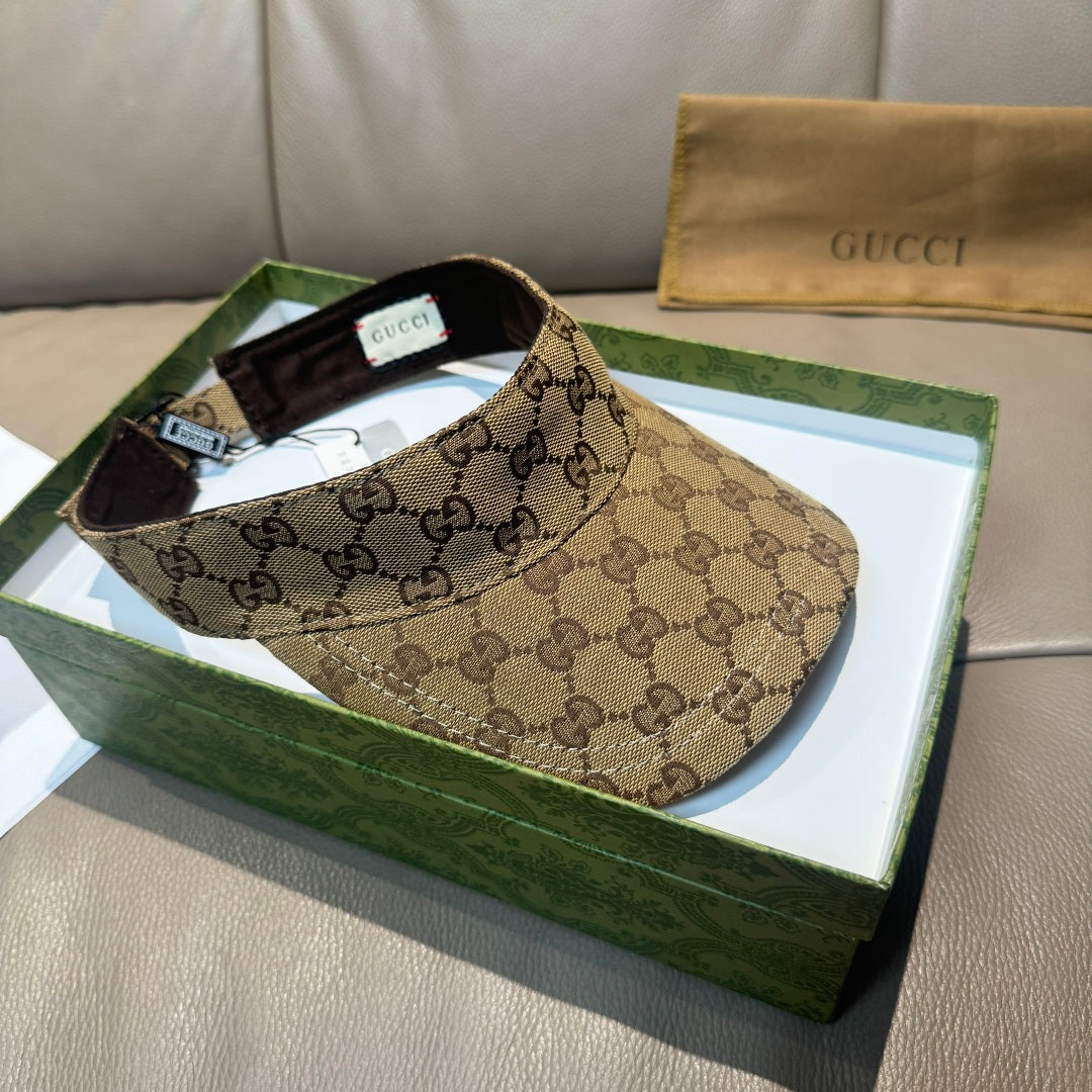 Brown GG monogram visor cap with black interior, front profile on green box