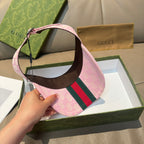 Pink visor cap with brown underside and green-and-red web stripe