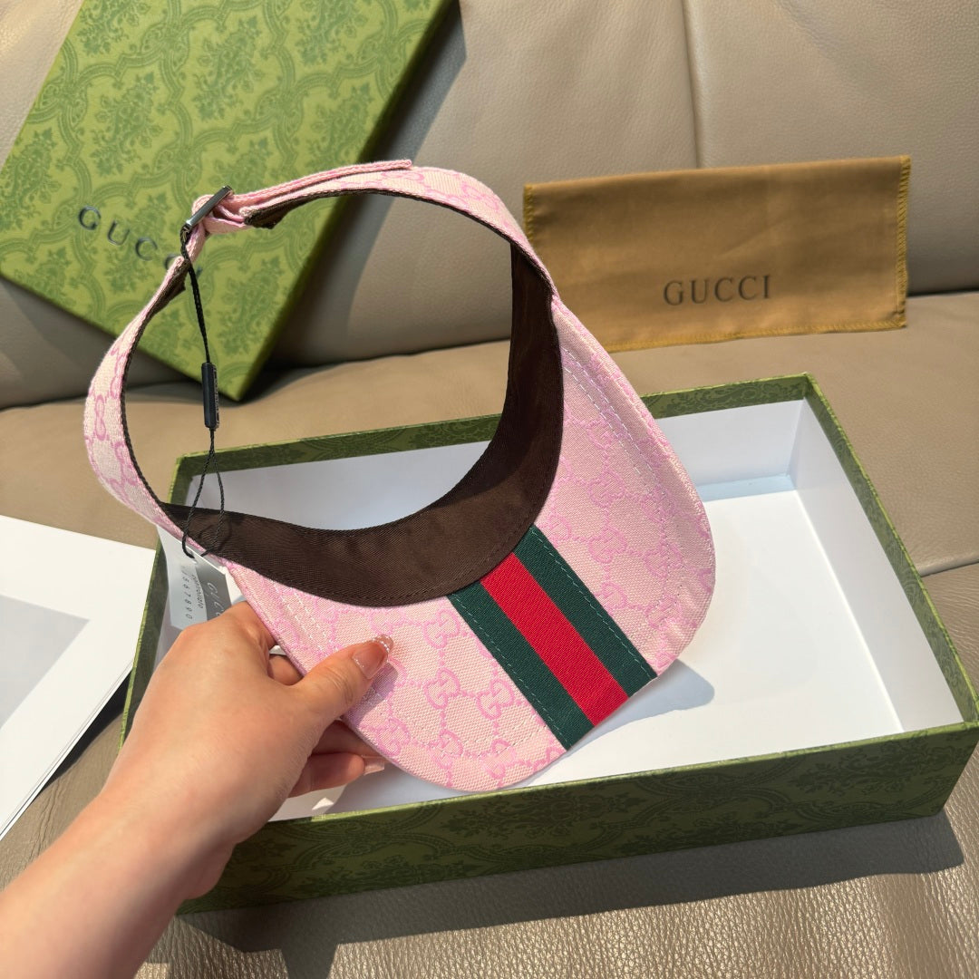 Pink visor cap with brown underside and green-and-red web stripe