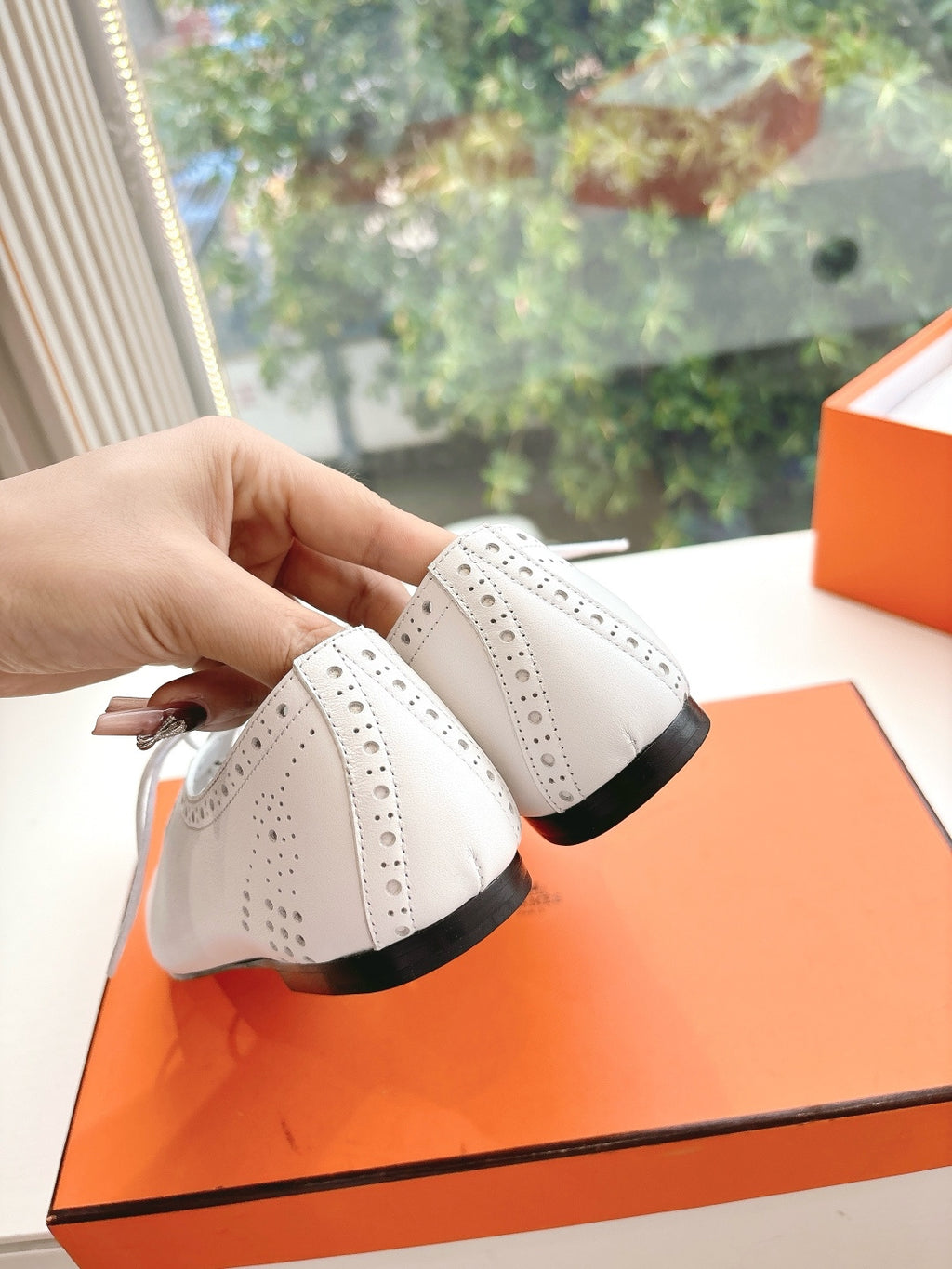 Hermes ladies white lace-up shoes close-up from side with black sole edge
