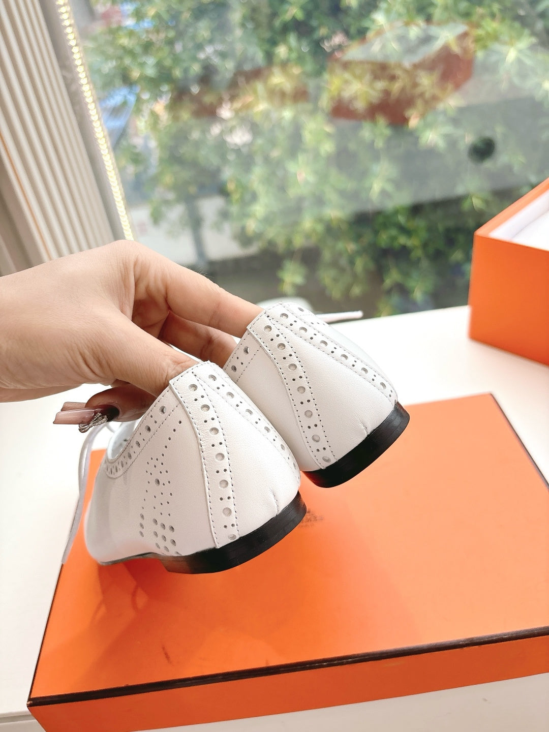 Hermes ladies white lace-up shoes close-up from side with black sole edge
