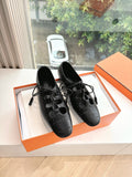 Black leather lace-up dress shoes with brogue-style perforations, pair view