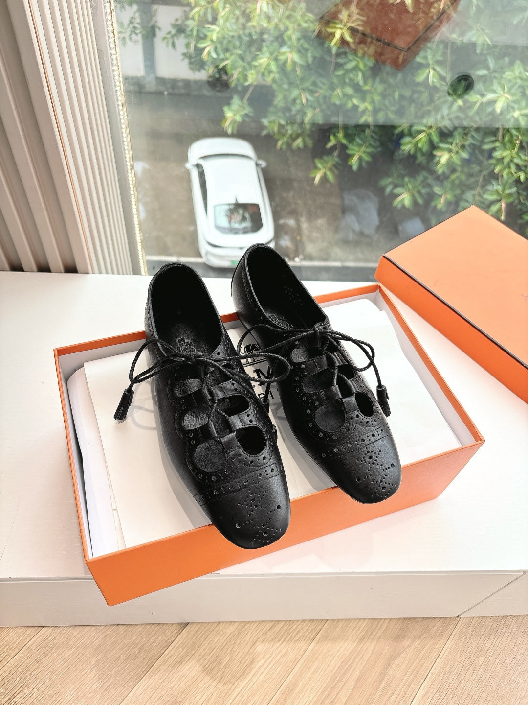 Black leather lace-up dress shoes with brogue-style perforations, pair view