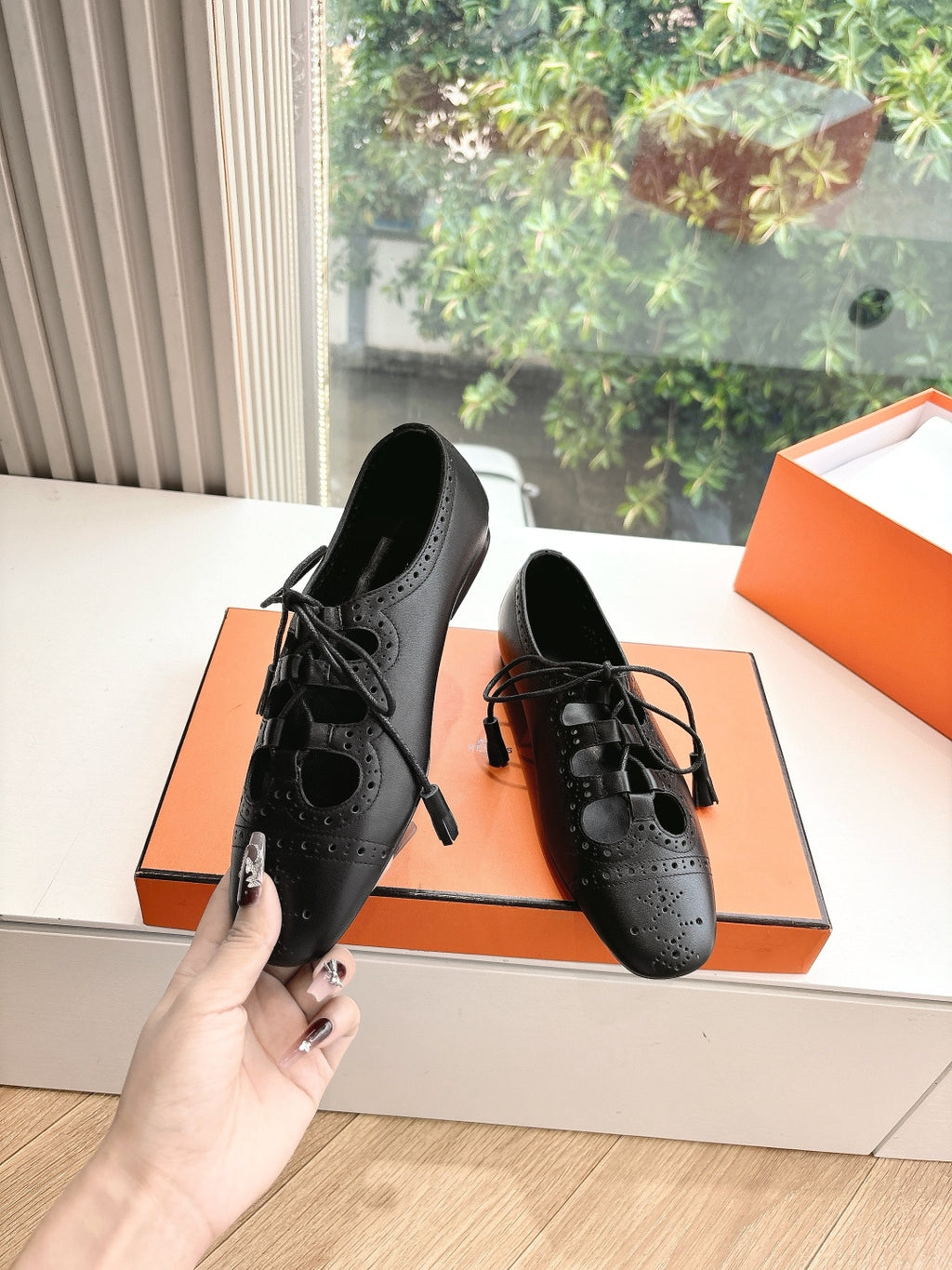 Black leather lace-up high-heel shoes with brogue-style perforations, pair view