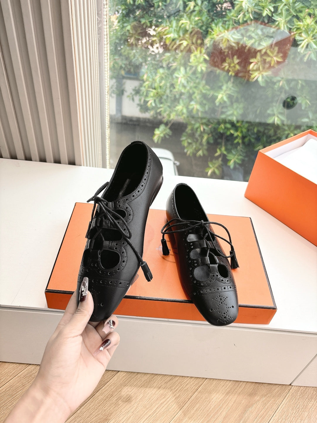 Black leather lace-up high-heel shoes with brogue-style perforations, pair view