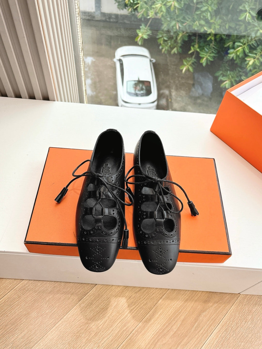 Black leather lace-up dress shoes with brogue-style perforations, front view pair