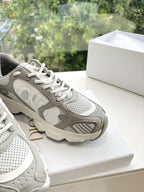 Close-up of women’s lace-up sneakers in light gray with perforated side panels