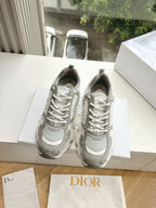 Pair of women’s lace-up sneakers in light gray with perforated mesh and textured toe cap