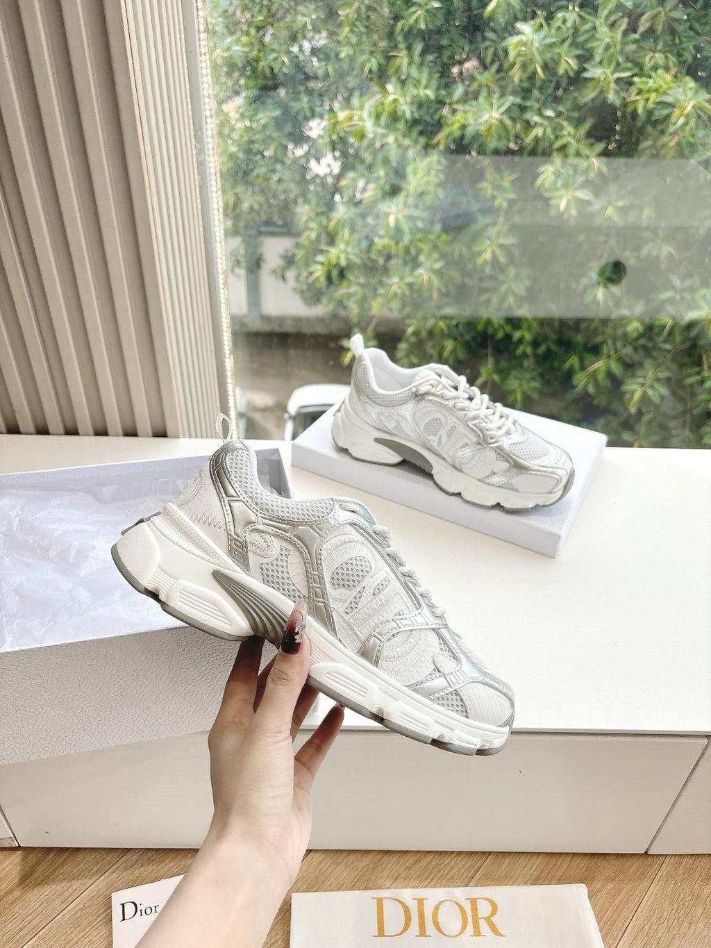 Dior women's white lace-up sneakers with textured mesh panels, held up for a closer look