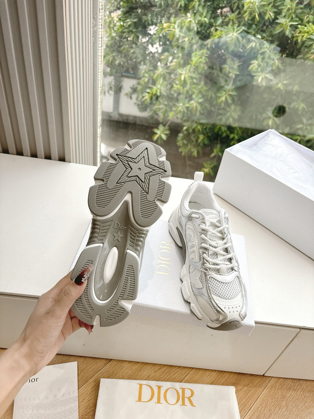 Dior women's white sneakers with star-pattern outsole, shown from the heel