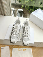 Dior women's white sneakers with lace-up front and chunky sole, resting on a box