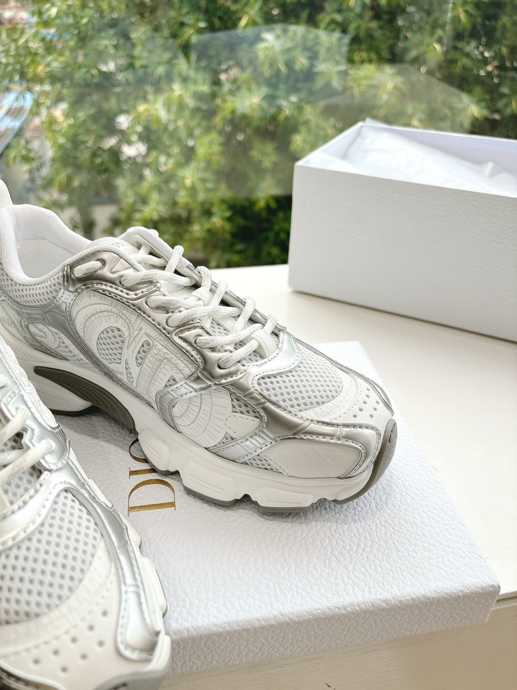 Dior women's white sneakers with detailed overlay patterns and lace-up front, close-up