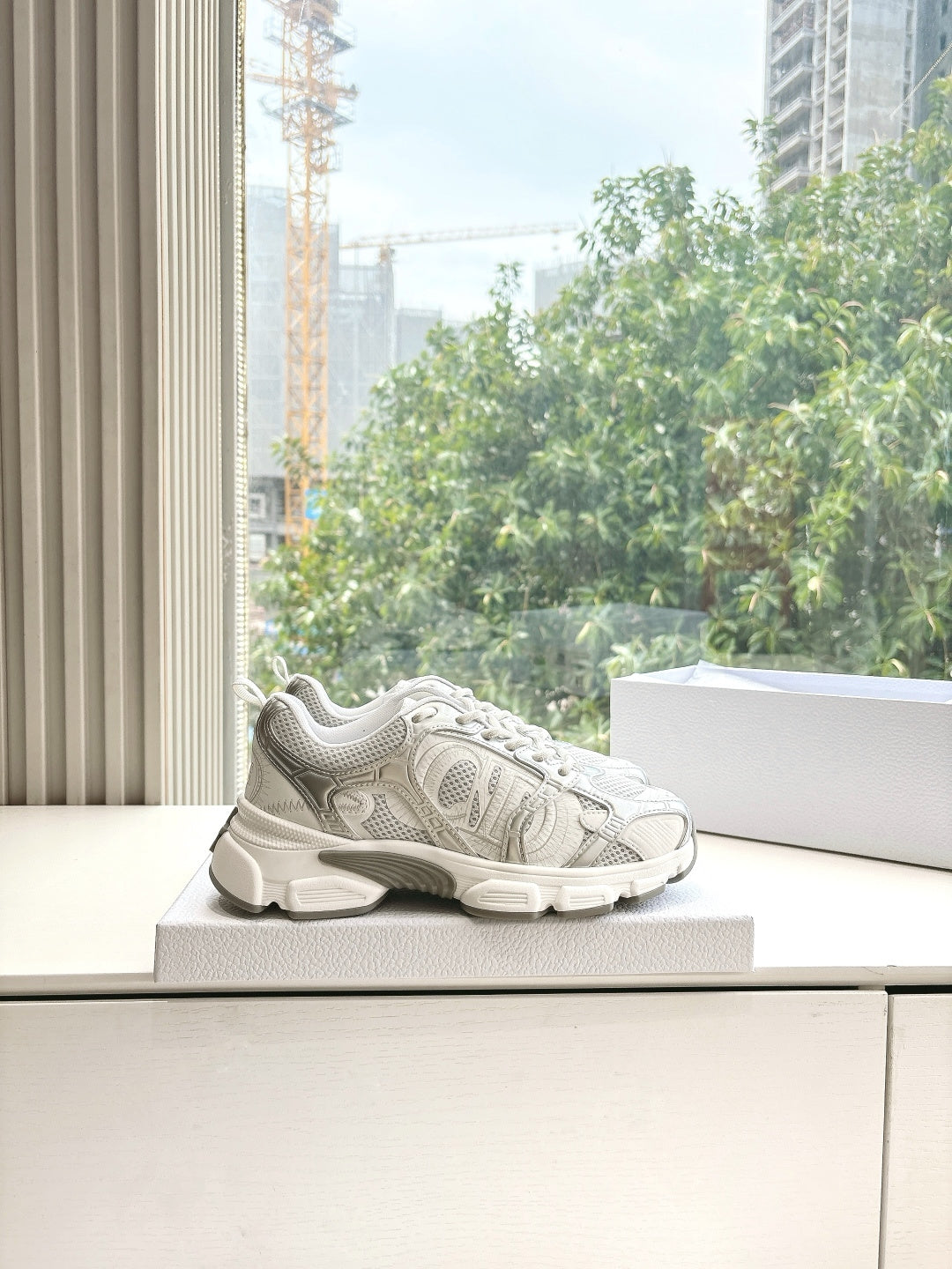 Dior women's white sneakers with textured uppers and lace-up closure, on display
