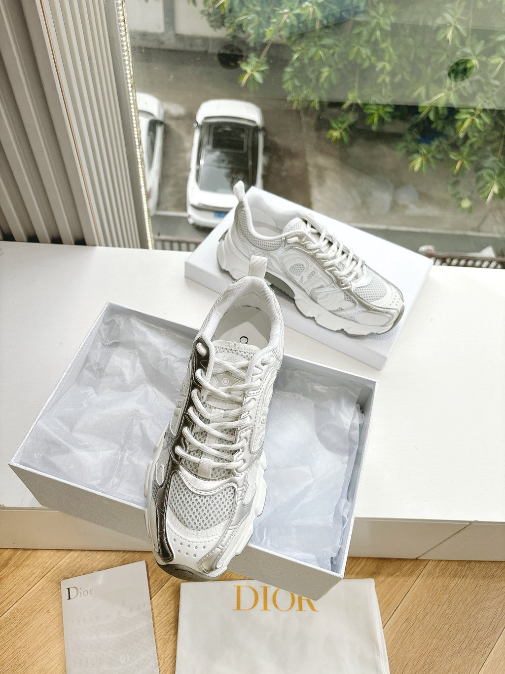 Dior women's white sneakers with sculpted sole and lace-up front, shown angled