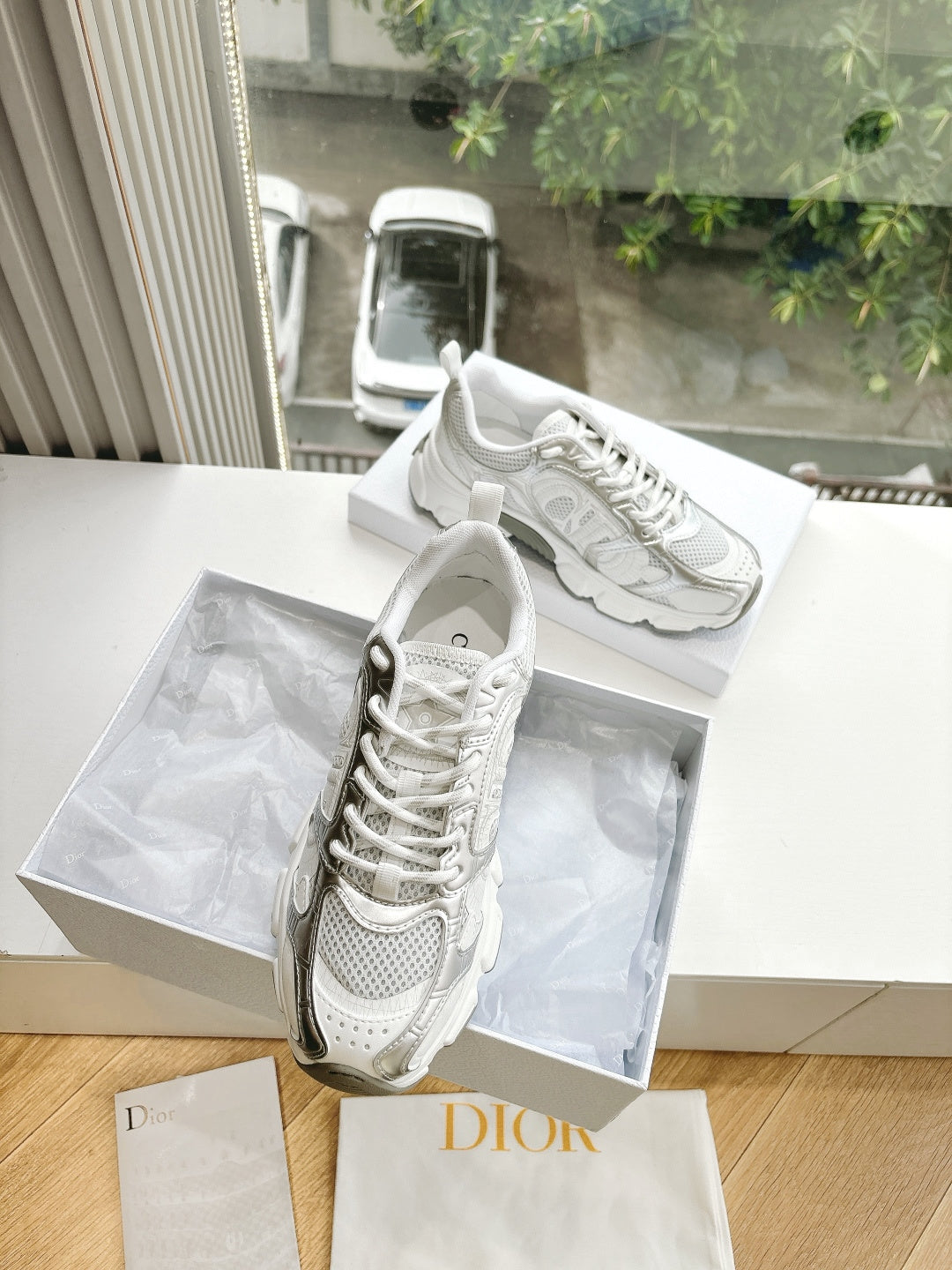 Dior women's white sneakers with sculpted sole and lace-up front, shown angled