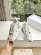 Dior women's white lace-up sneakers with textured design details, held in-hand