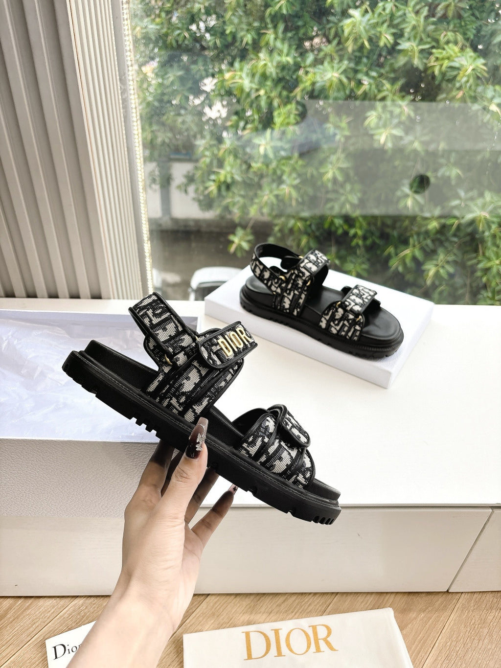 Black Dior sandals with patterned straps and chunky tread sole, side view