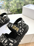 Black Dior sandals with monogram strap across the foot and padded black footbed