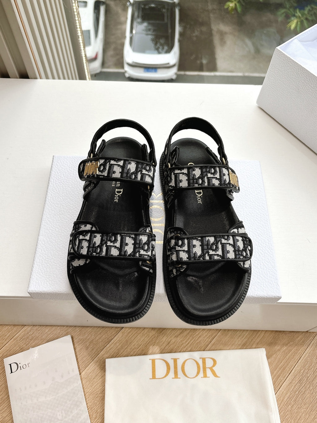 Black Dior sandals with monogram-printed straps and adjustable ankle buckle