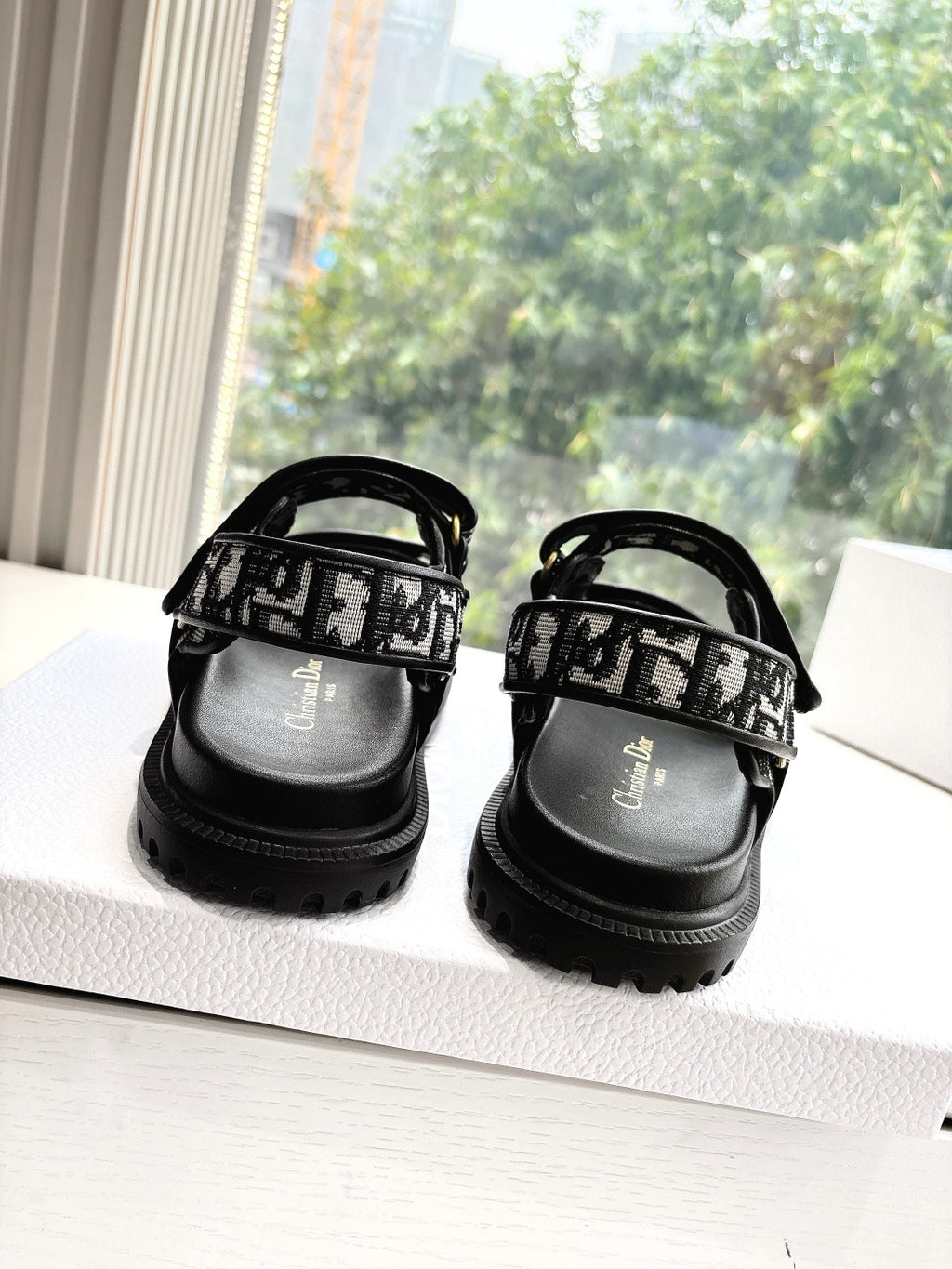 Black Dior sandals with monogram straps and low-profile treaded sole